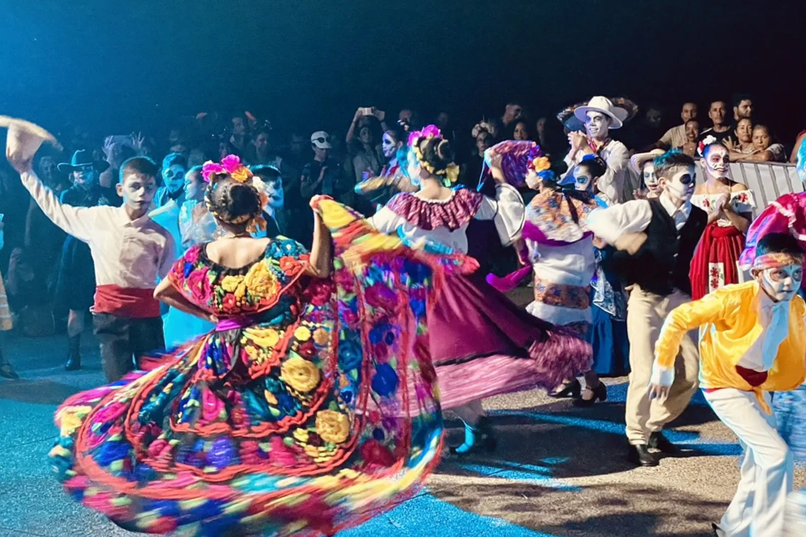 Children dancing at night in traditional costumes for the Day of The Dead